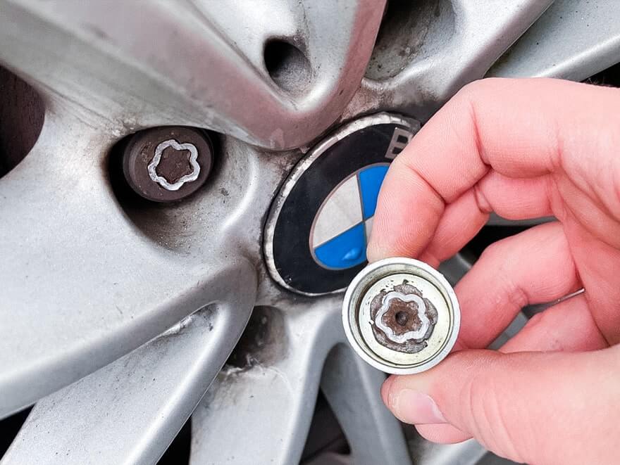 Locking wheel nut removal technician at work