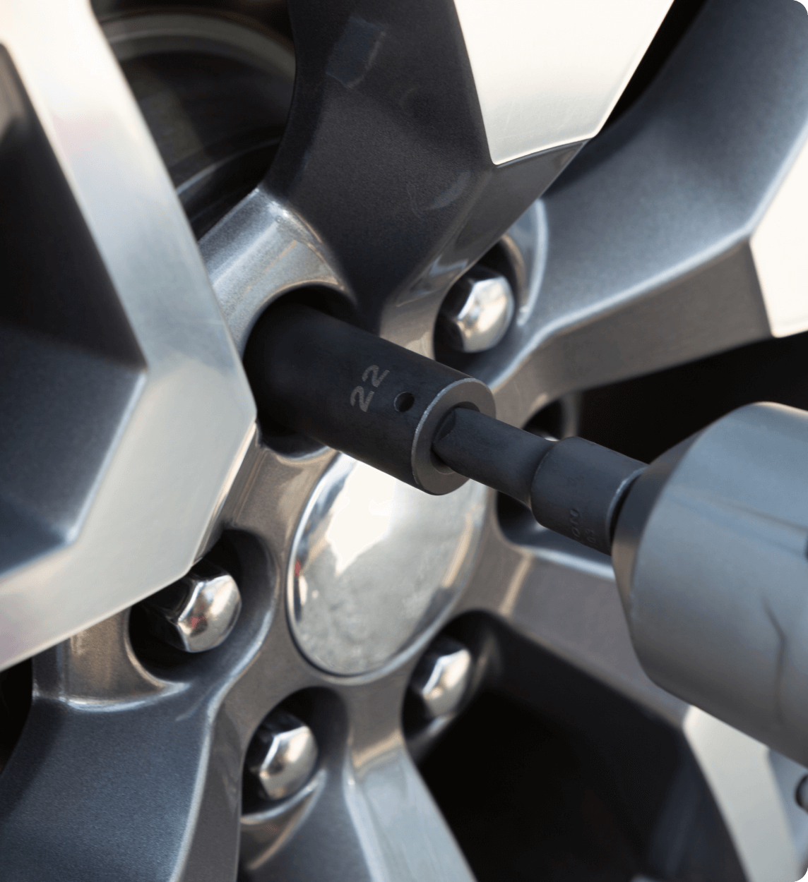 Locking wheel nut removal technician assisting a customer